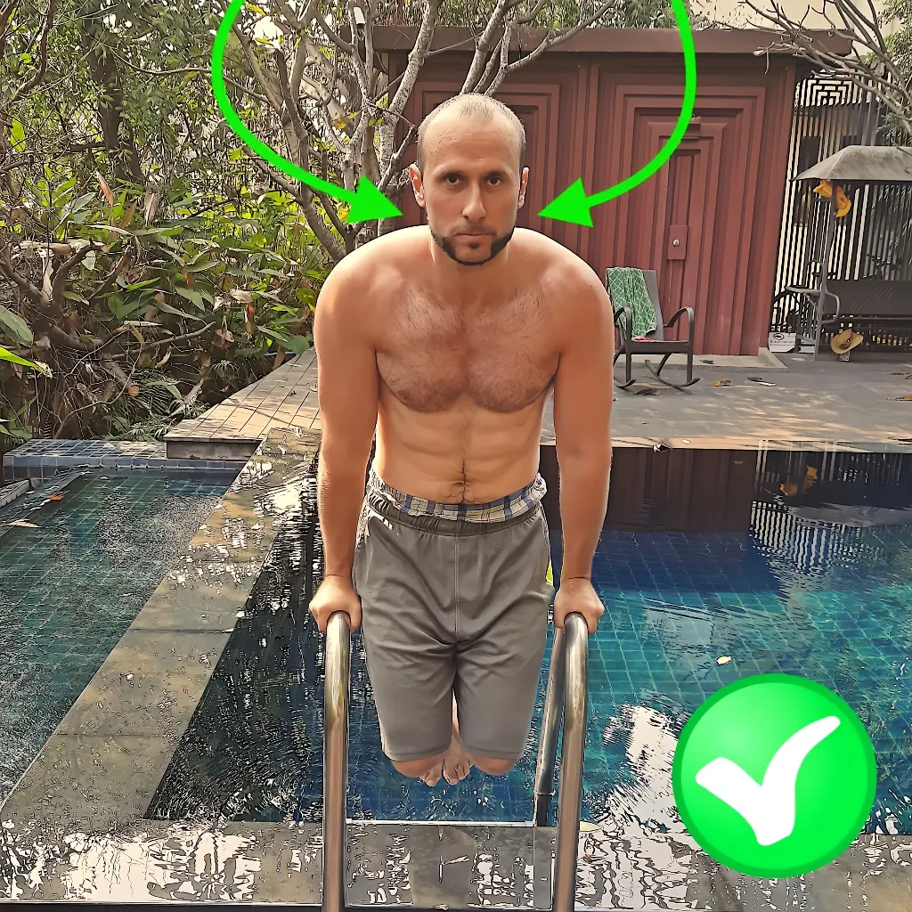 Demonstrating proper shoulder and trap position on a parallel bar bodyweight dip