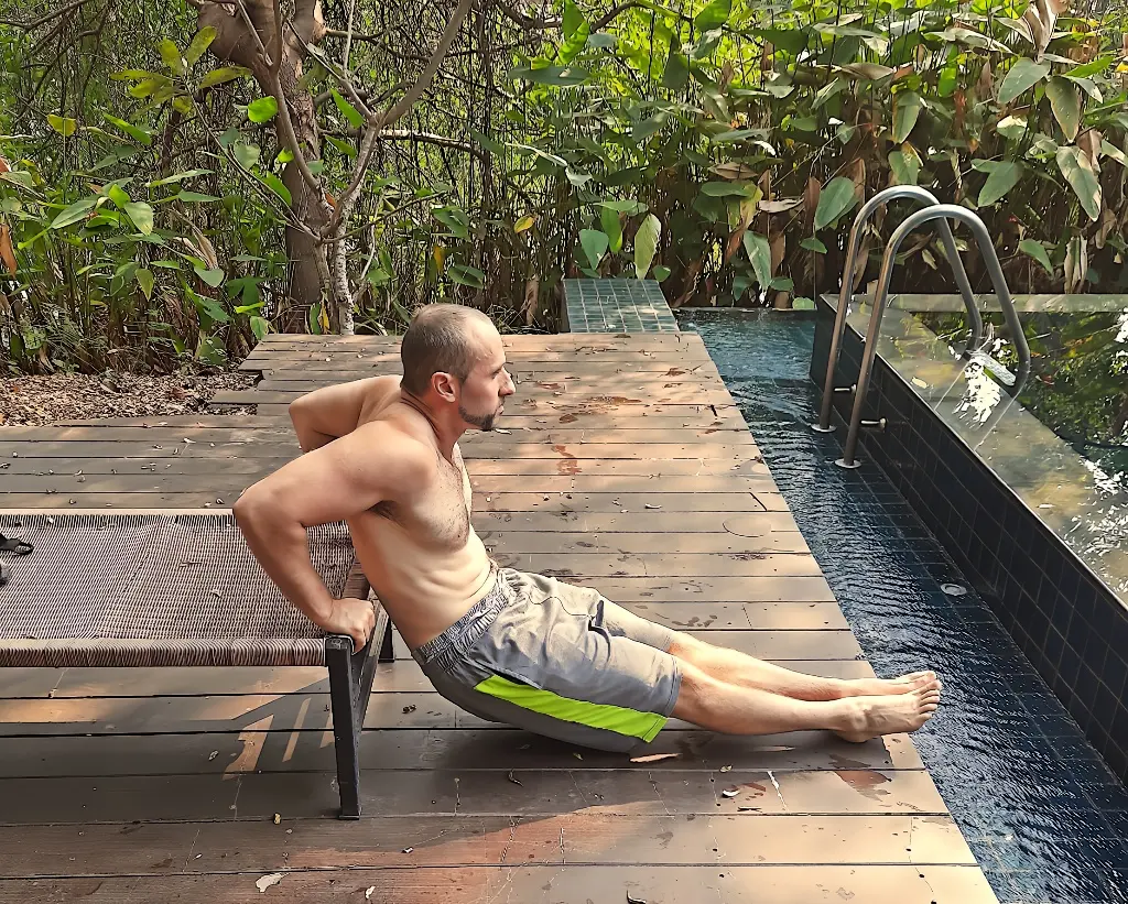 Demonstrating the bottom position of a tricep dip
