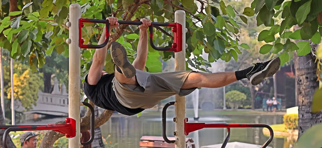 Straddle front lever on an outdoor pullup bar at Buak Hard Park in Chiang Mai