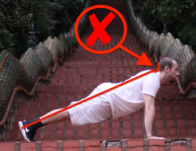 Demonstrating incorrect plank form with unnecessary neck straining
