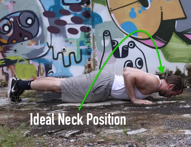 Demonstrating proper alignment with a neutral spine in the down portion of a pushup