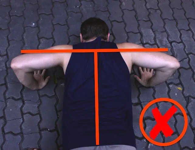 Demonstrating incorrect arm alignment during a pushup. The image is from directly above the upper body and shows the elbows flaring out to make a 'T' shape