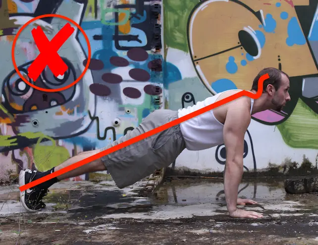 Demonstrating unnecessary neck strain in the up portion of a pushup