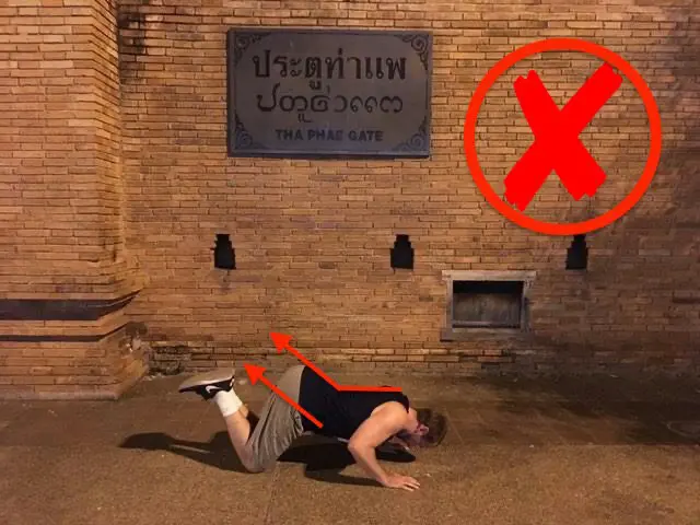 Demonstrating incorrect alignment in the bottom portion of the on-your-knees pushup variation