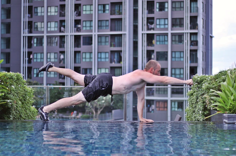 Demonstrating one arm + one leg plank variation