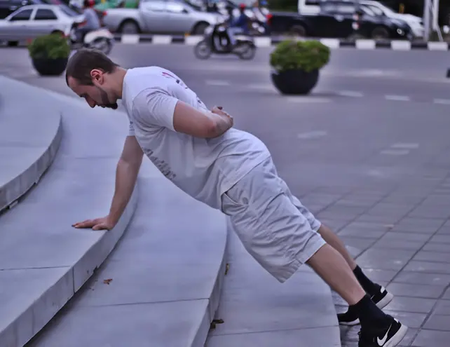 One arm pushup progression with upper body elevated on a platform