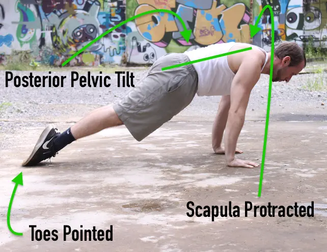 Showing the up portion of a gymnast style pushup, with toes pointed and a posterior pelvic tilt
