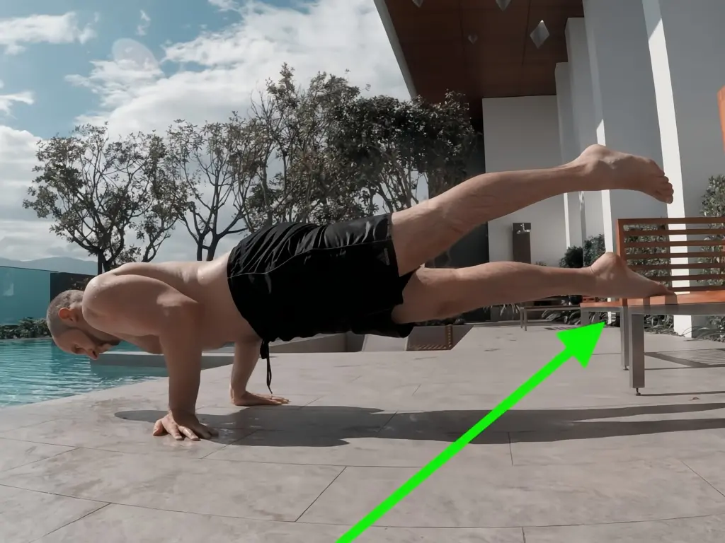 Self-spotted elbow lever where one foot rests on a bench and the other is lifted slightly into the air