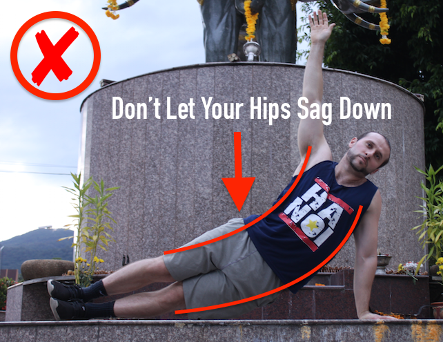 Demonstrating incorrect side plank form with hips sagging down