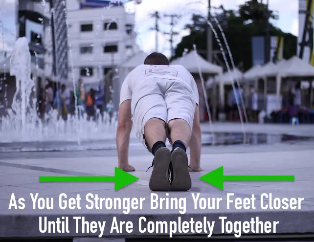 Demonstrating a standard pushup from behind, with legs and feet together