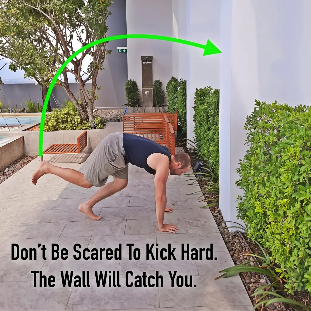 Getting ready to begin the toe taps drill, with one leg ready to kick against the wall.
