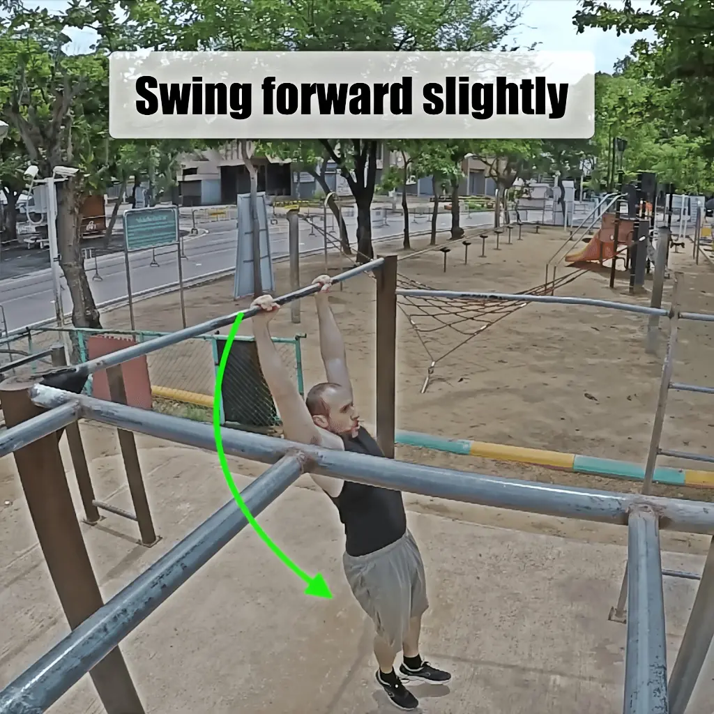 Swinging forward slightly on the pullup bar to begin the movement