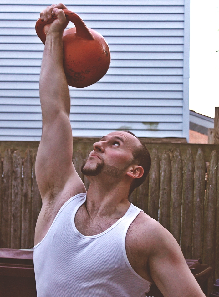 One-arm kettlebell press demonstrating proper technique